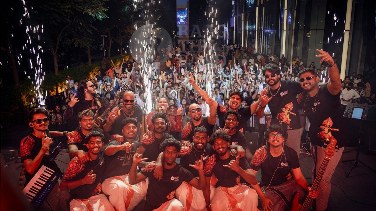The band celebrating with a crowd under cold sparklers